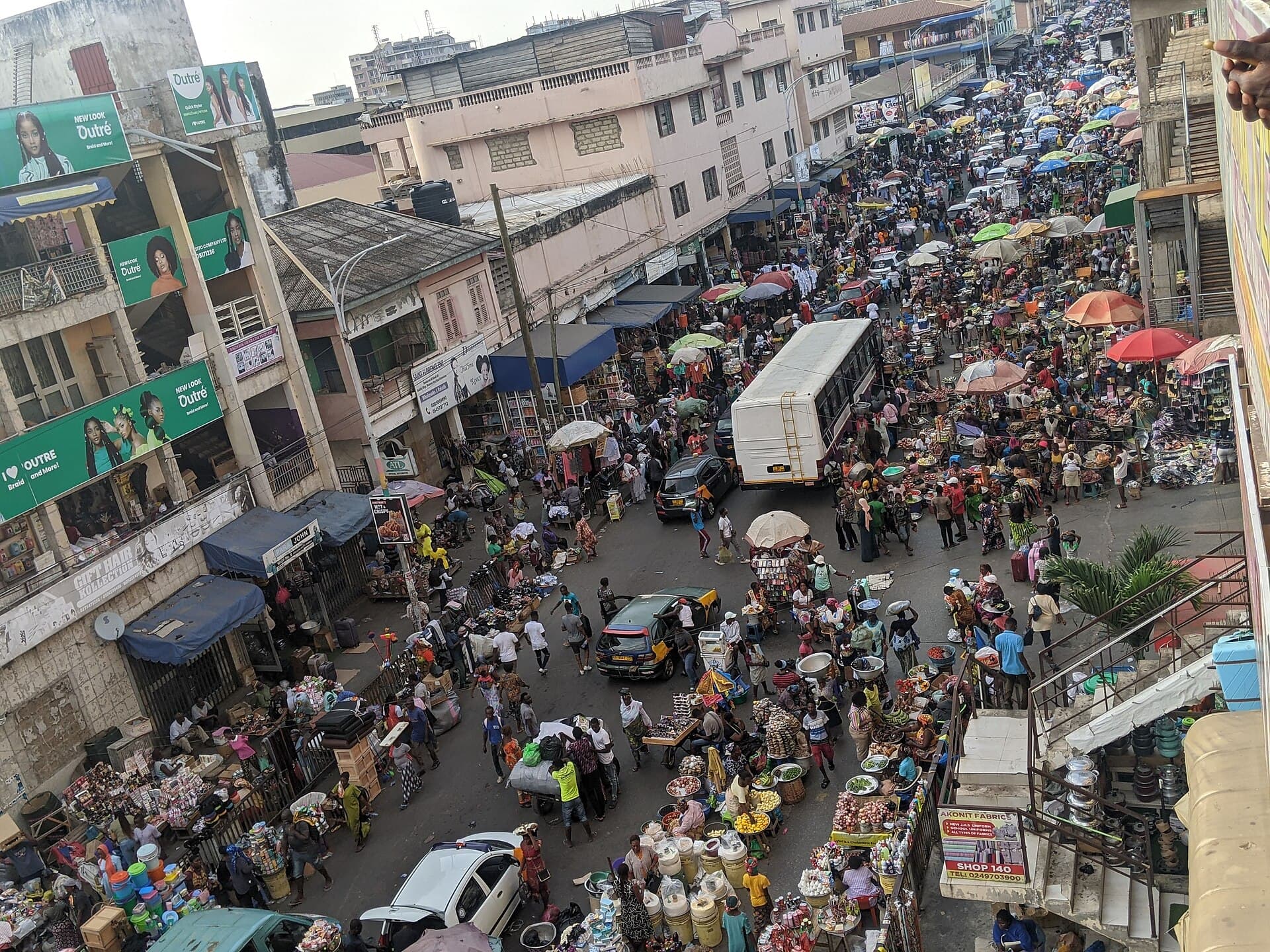 Busy street at Makola Market in Accra seen from above, full of traders, shoppers and umbrellas